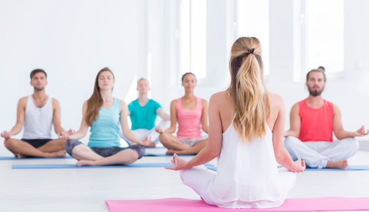 People doing yoga in white room